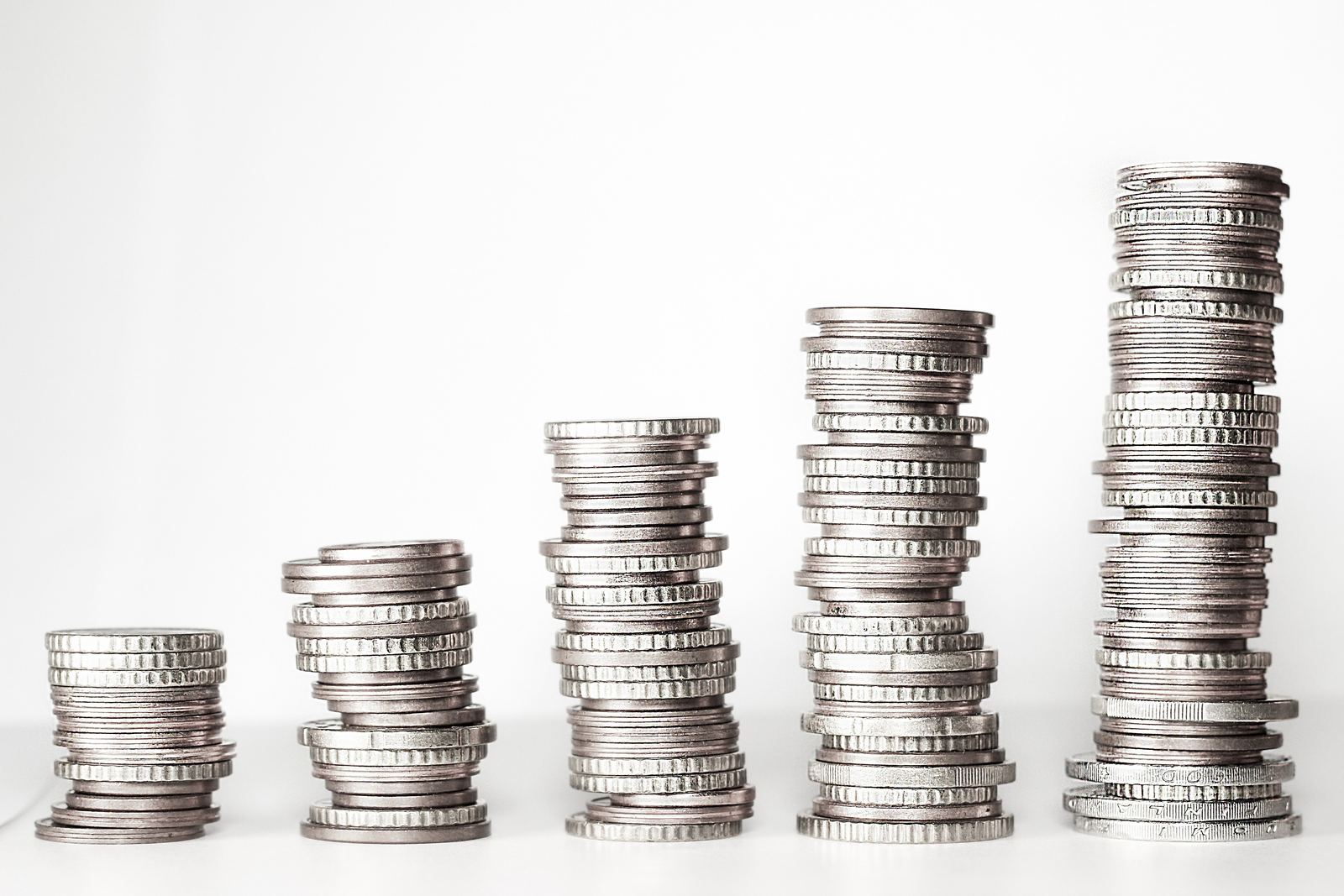 Five stacks of coins of increasing height on a table