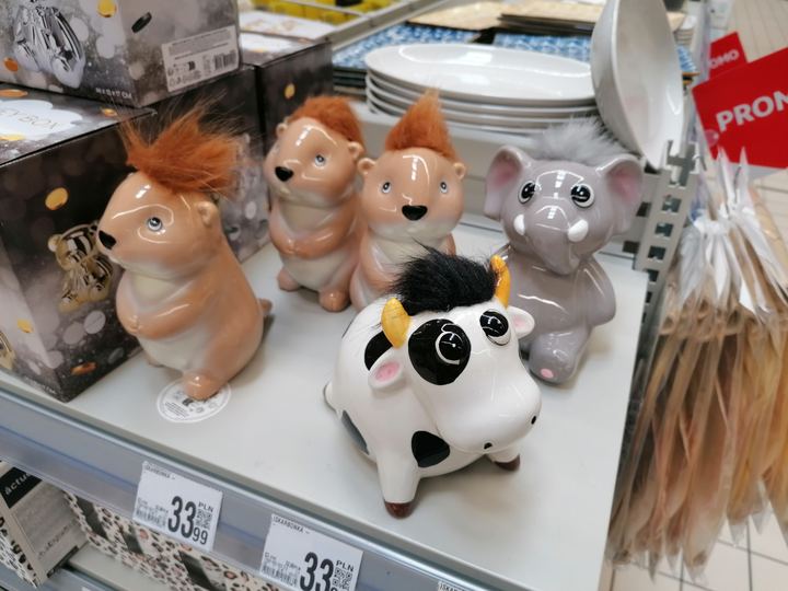Rows of colorful ceramic piggy banks on a store shelf