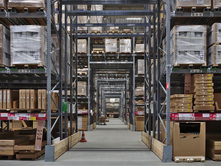 Tall aisles of flat-packed furniture boxes in an IKEA self-serve warehouse in Belgium