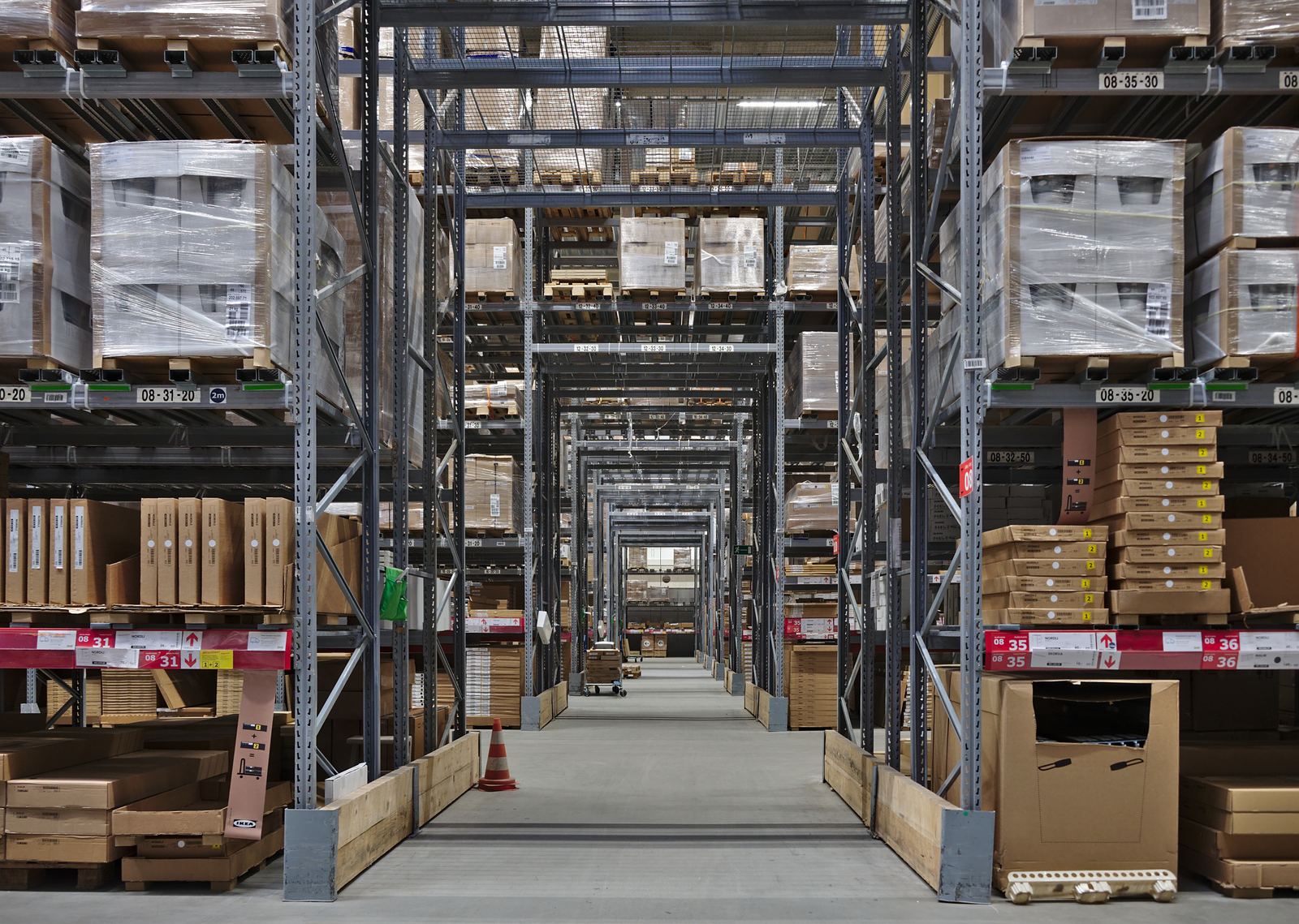 Tall aisles of flat-packed furniture boxes in an IKEA self-serve warehouse in Belgium
