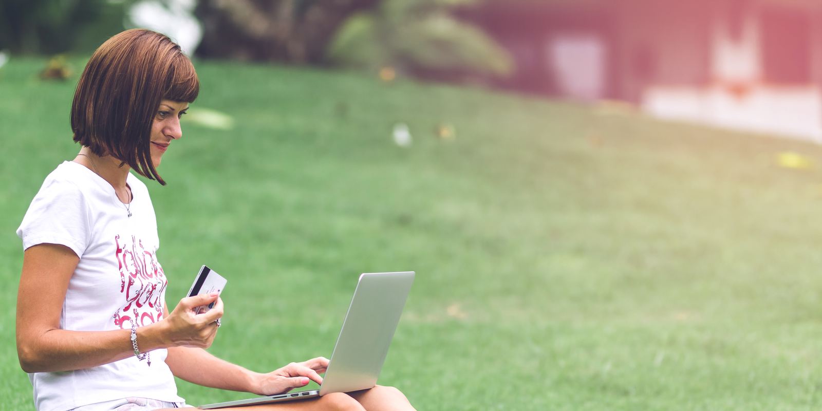 A person using a laptop outdoors in a park
